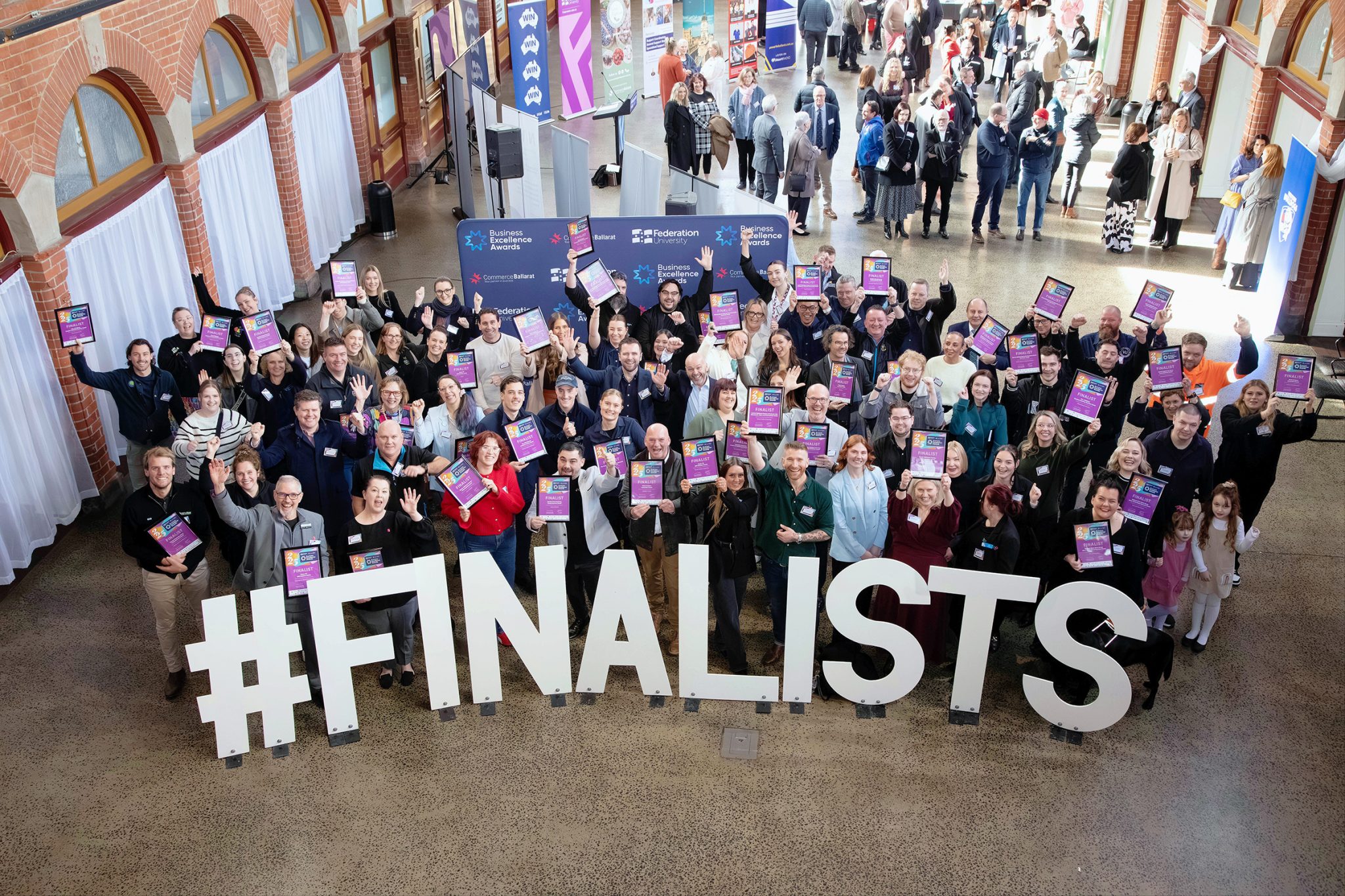 Group of award finalists holding certificates, smiling.