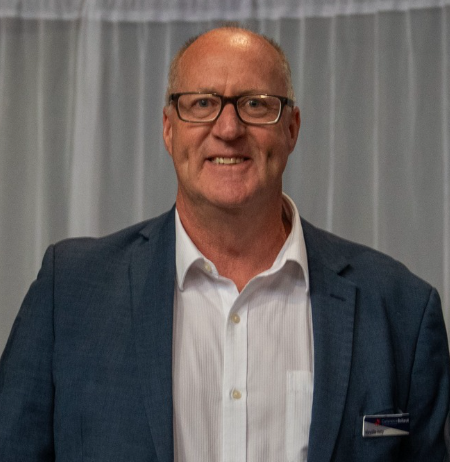 Man smiling in a blue suit jacket.