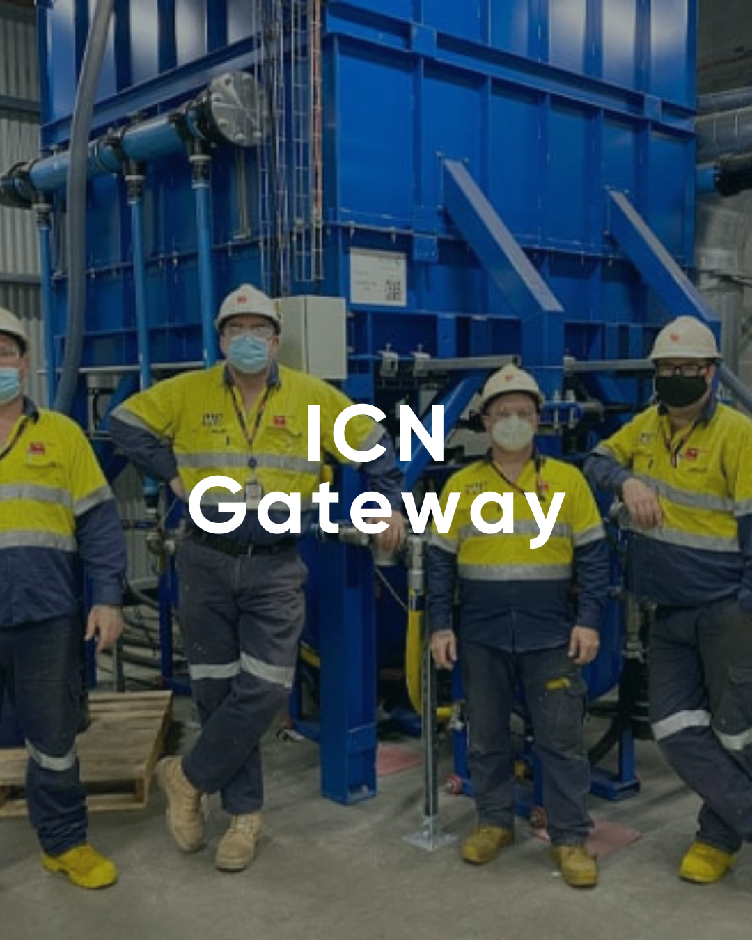 Workers at industrial site with machinery.