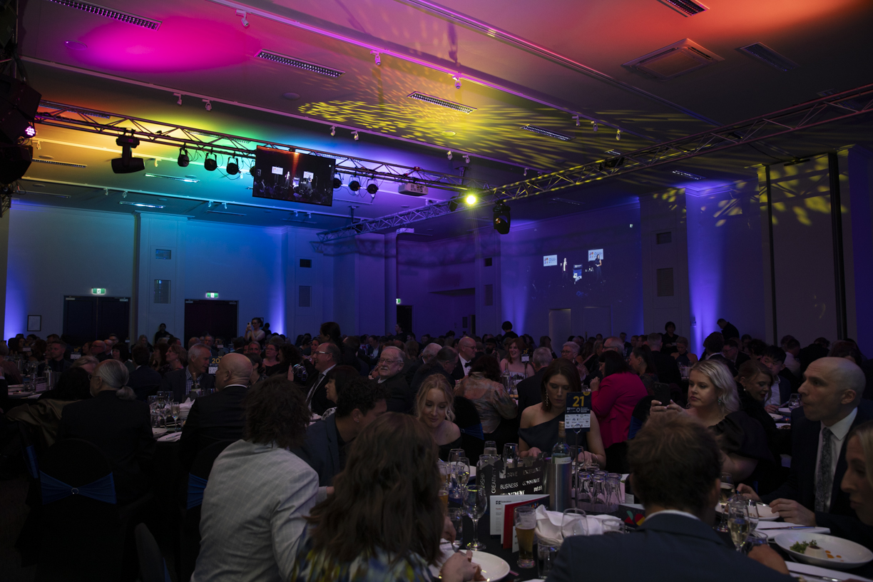 Gala dinner with colourful lights and guests seated.