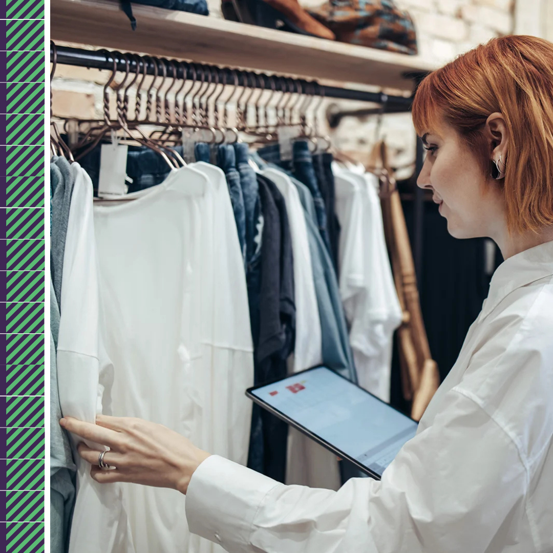 Person browsing clothes with tablet in store.
