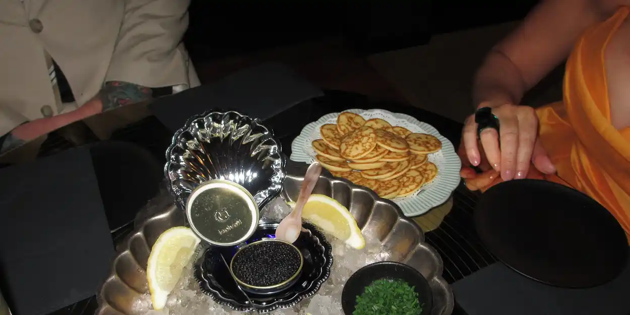 Caviar with blinis and lemon slices on table