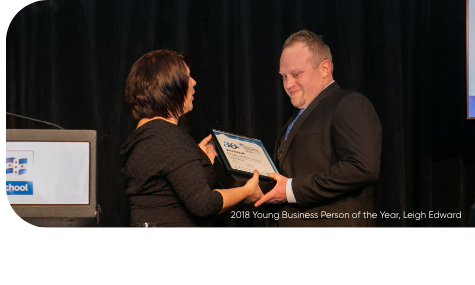 Award ceremony with two people exchanging certificate.