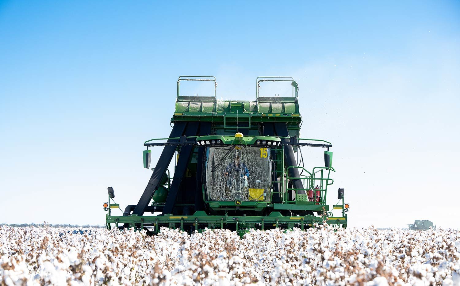 Cotton harvester machine operating in a field